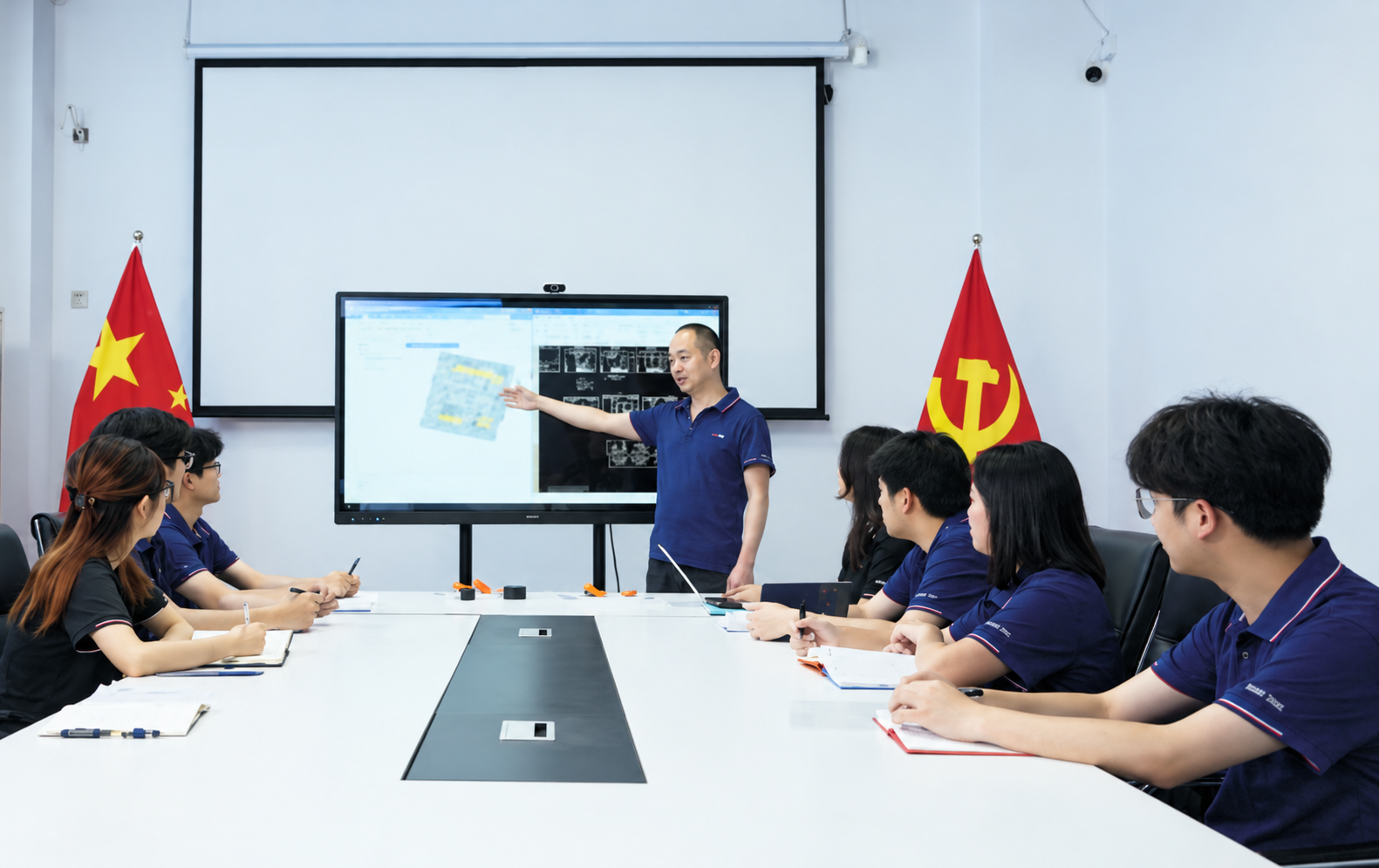 CHENHOTECH team meeting around a conference table in orange workwear